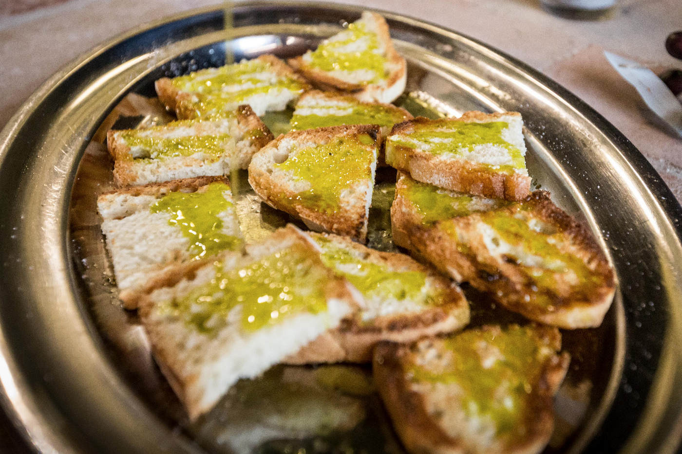 Ein Teller mit gerösteten Weißbrotscheiben, gewürzt mit nativem Gardasee-Olivenöl extra