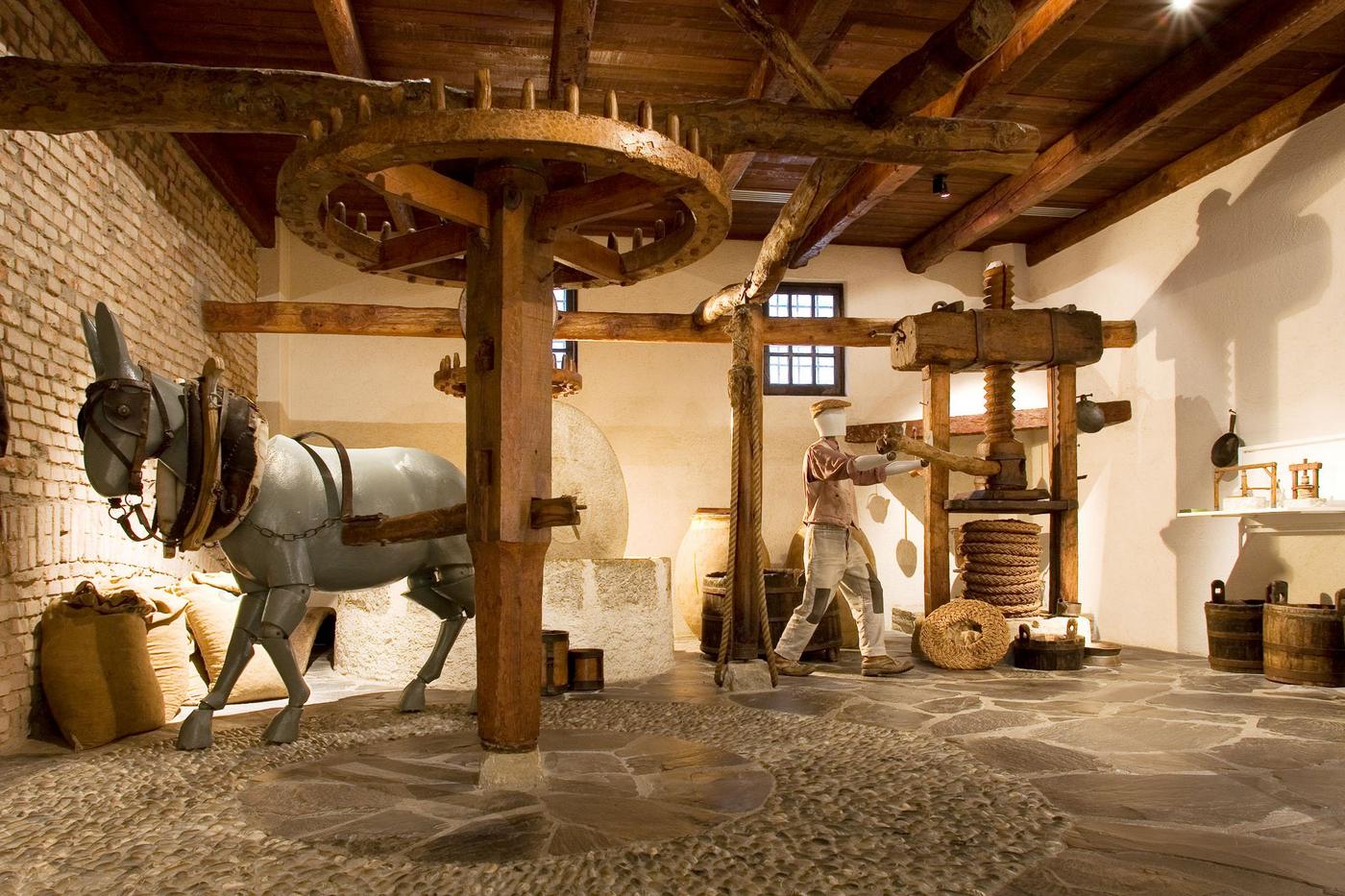Lebensgroße Rekonstruktion einer antiken, von Tieren angetriebenen Olivenpresse und einer manuellen Holzpresse