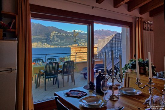 Detail auf dem Tisch und im Hintergrund der Blick auf den See aus dem Fenster